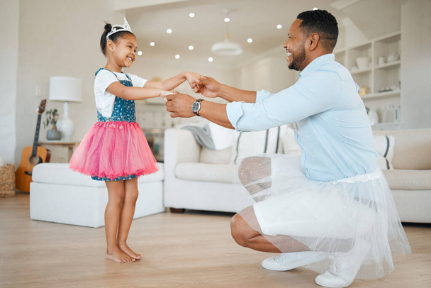 Shot of an adorable little girl wearing a tutu and dancing with her father in the living room. - Zdjęcie, obraz