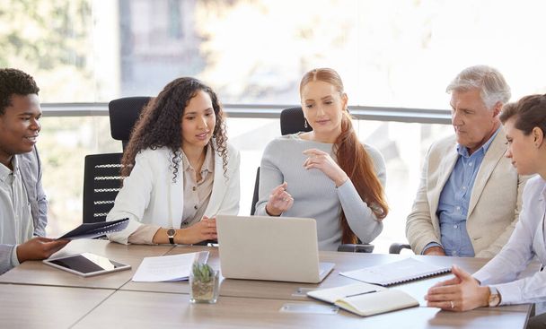 Знімок різноманітної групи бізнесменів, які сидять в офісі разом і використовують ноутбук під час зустрічі
. - Фото, зображення