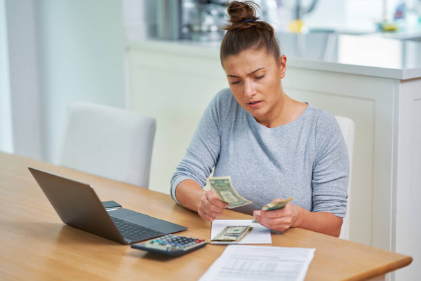 Mulher jovem contando orçamento em casa com contas. Foto de alta qualidade - Foto, Imagem