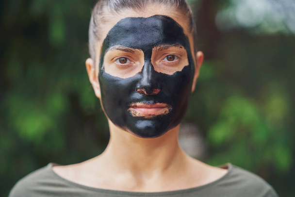 Mujer joven en la naturaleza con máscara negra en la cara. Foto de alta calidad - Foto, imagen