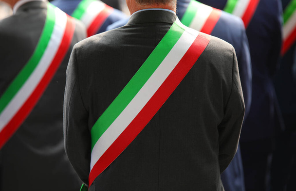 πολλοί κομψοί Ιταλοί δήμαρχοι με κομψό φόρεμα κατά τη διάρκεια της επίσημης τελετής με την τρίχρωμη πράσινη λευκή και κόκκινη κορδέλα - Φωτογραφία, εικόνα