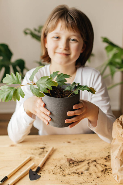 A lány talajt gyűjt tőzegedényekben vetőmagok ültetéséhez. Tavaszi kertészeti hobbi az egész családnak. Vetés - Fotó, kép