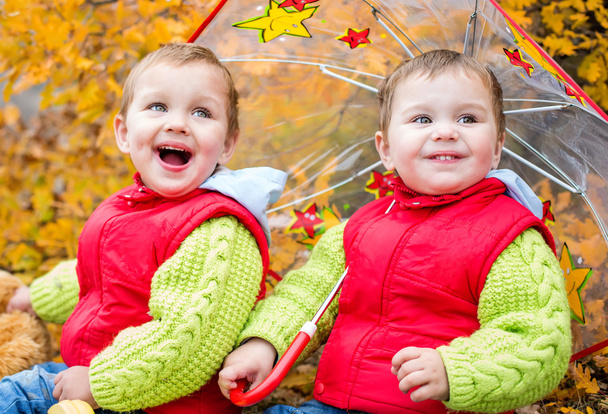 Kisgyermek boldog gyermekek alatt egy esernyő - Fotó, kép