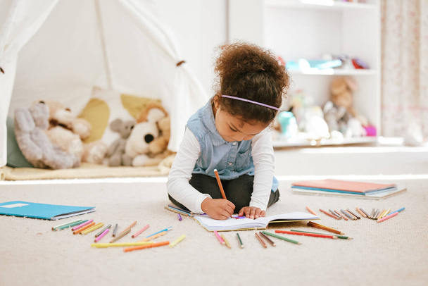 Φωτογραφία ενός μικρού κοριτσιού που χαλαρώνει και ζωγραφίζει στο σπίτι. - Φωτογραφία, εικόνα
