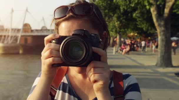 Imágenes de video de 4k de una mujer joven tomando fotos con una cámara mientras explora una ciudad. - Imágenes, Vídeo