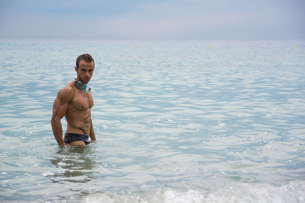 Handsome muscular young man standing in the sea - Fotoğraf, Görsel