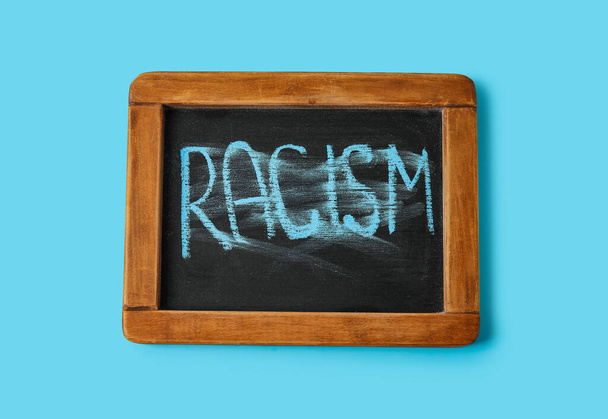 Chalkboard with written word RACISM on color background - Photo, Image
