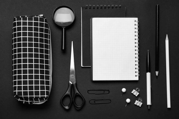 Pencil case and different stationery on dark background - 写真・画像