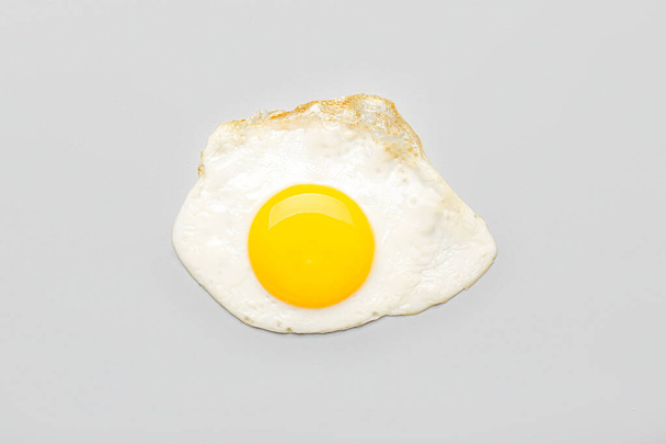 Tasty fried egg on light background - Fotoğraf, Görsel