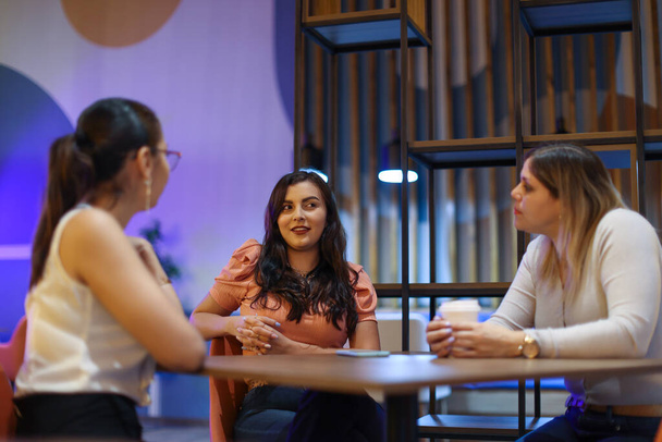 Přátelé mluví s úsměvem v kavárně s fialovým pozadím. Kvalitní fotografie - Fotografie, Obrázek