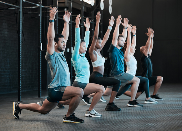 Shot of a group of people doing lunges together at the gym. - 写真・画像