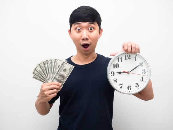 Мужчина взволнован эмоциями, держа в руках аналоговые часы и много денег - Фото, изображение