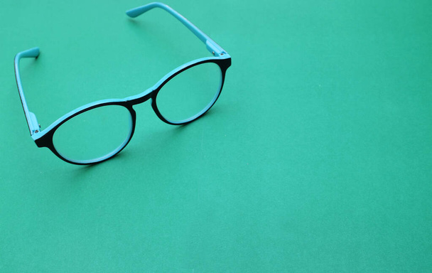 Чистые очки, голубая рамка с проволокой полоса современный стиль на зеленом фоне - Фото, изображение