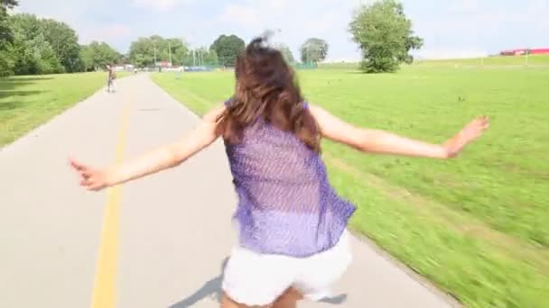 Young attractive woman rollerblading in park on a beautiful sunny day. - Materiaali, video