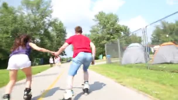 Γυναίκα και άντρας rollerblading σε μια ηλιόλουστη ημέρα στο πάρκο - Πλάνα, βίντεο