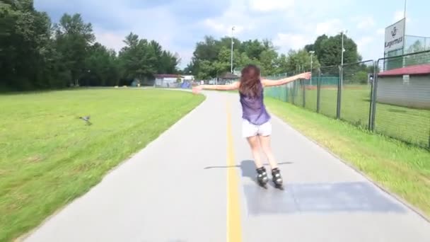 Young attractive woman rollerblading in park on a beautiful sunny day. - Filmagem, Vídeo