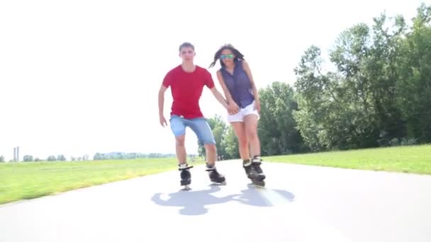 Happy young couple rollerblading - Кадры, видео