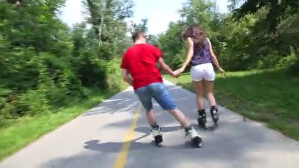 Woman and man rollerblading on a sunny day in park - Filmmaterial, Video