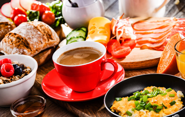 Завтрак подается с кофе, апельсиновым соком, яичницей, крупой, ветчиной и сыром. - Фото, изображение