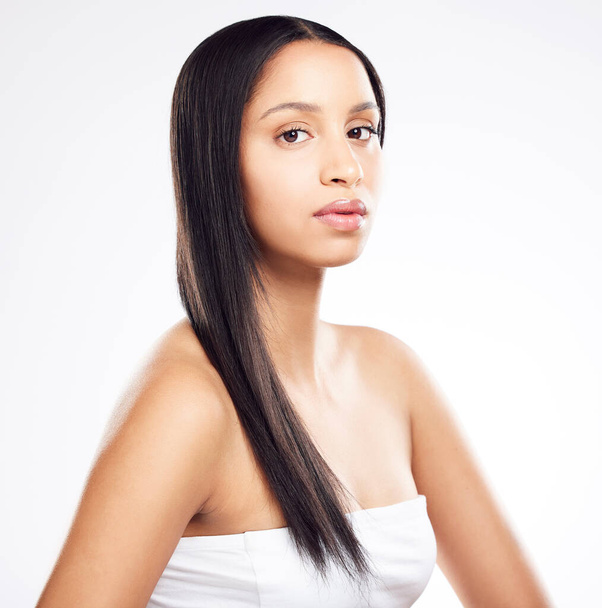 Shot of a young woman posing against a white background with healthy looking hair. - Foto, Bild