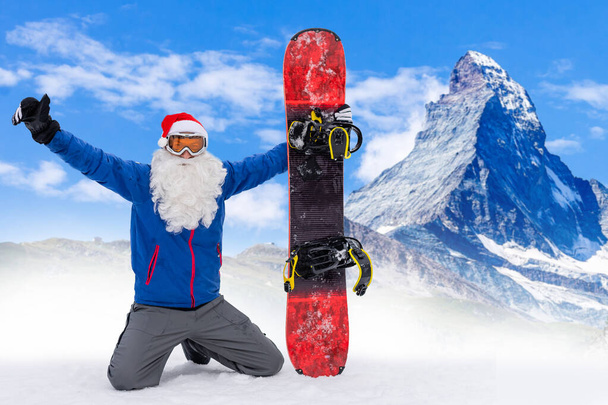 Santa Claus on a snowboard. Man in a red suit Santa Claus with a white beard in a ski mask jumped on a snowboard. The ski slope. - Foto, imagen