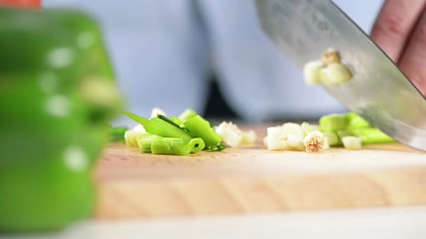 4k video footage of a man slicing into spring onion while preparing a meal. - Video