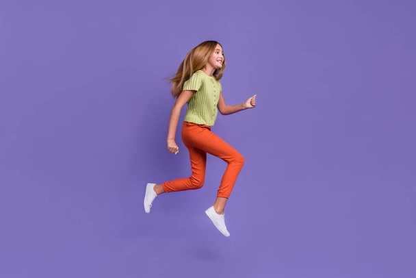 Full size profile portrait of crazy cheerful girl jump hurry rush empty space isolated on purple color background. - Fotografie, Obrázek