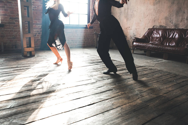 2人のプロのダンサーのカップルの足はロフトスタジオで踊っています。煙の多い美しいアートパフォーマンス。スポーツライフのコンセプト。情熱と感情のダンス. - 写真・画像