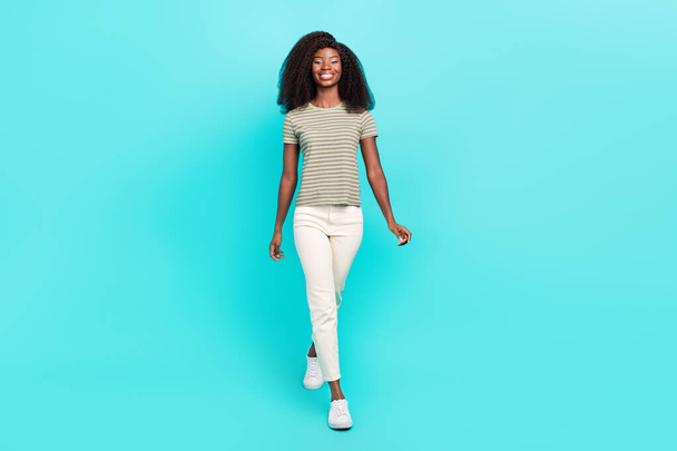 Full length photo of charming cheerful girl walking have good mood isolated on bright aquamarine color background. - Zdjęcie, obraz