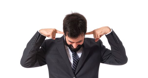 Businessman covering his ears over white background - Foto, Bild