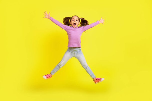 Full size photo of excited school child jump high moving scream isolated shine vibrant color background. - Фото, зображення