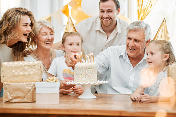 Φωτογραφία μιας ευτυχισμένης οικογένειας που γιορτάζει τα γενέθλιά της στο σπίτι. - Φωτογραφία, εικόνα