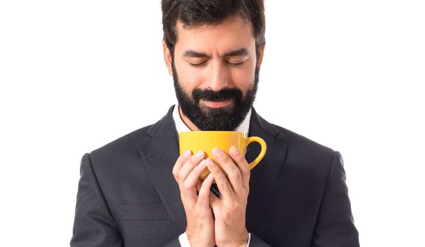 Empresario sosteniendo una taza de café sobre fondo blanco
 - Foto, imagen
