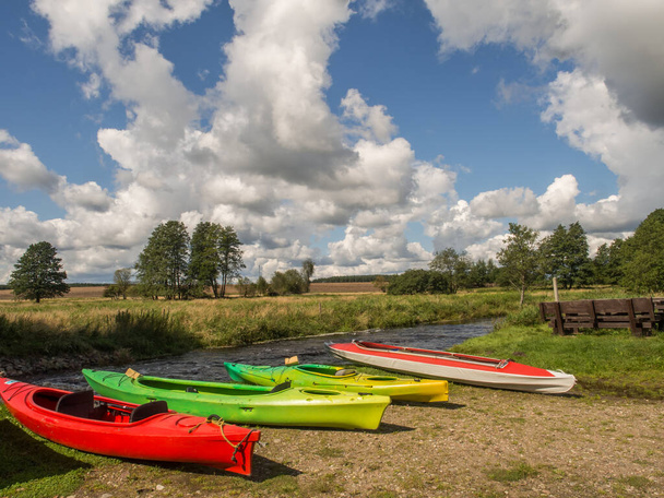 Verschiedene farbige Kajaks am Ufer des Flusses. Wieprza. Polen - Foto, Bild