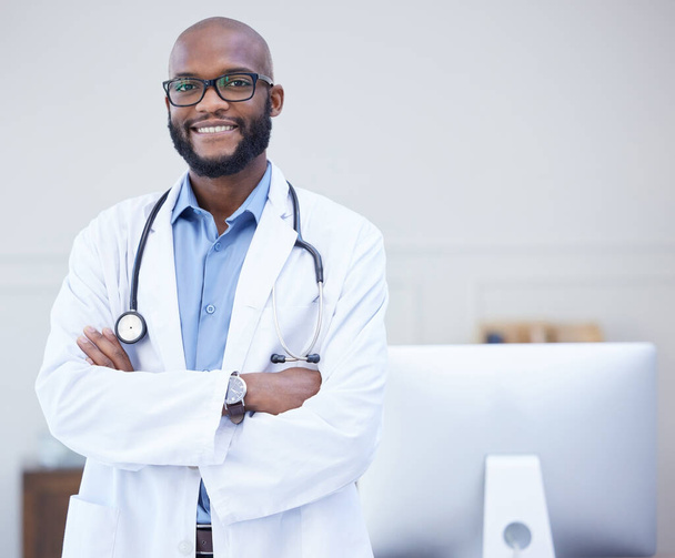 Shot of a young male doctor standing with his arms crossed in an office at a hospital. - Photo, image