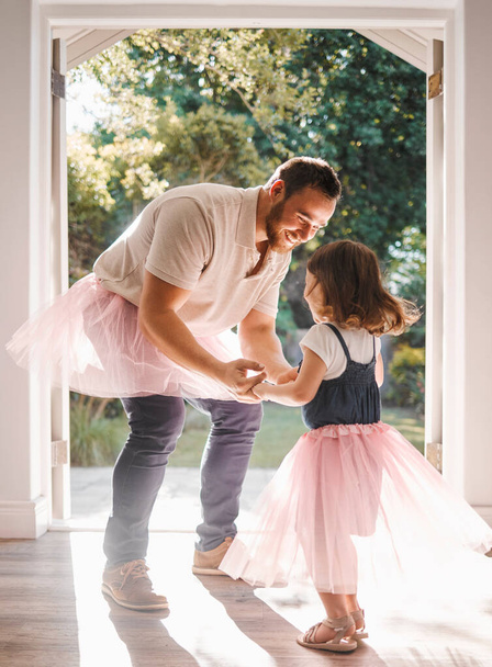 Foto de una adorable jovencita y su padre bailando juntos en casa. - Foto, Imagen