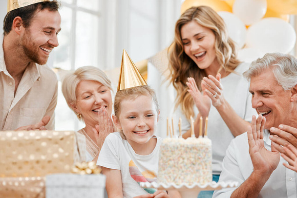 Φωτογραφία μιας ευτυχισμένης οικογένειας που γιορτάζει τα γενέθλιά της στο σπίτι. - Φωτογραφία, εικόνα