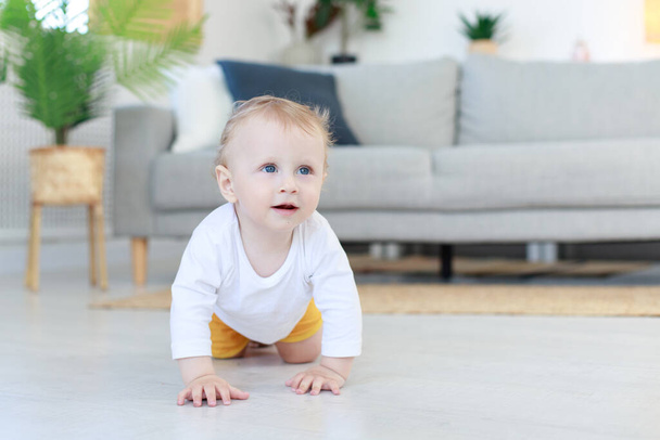 the baby crawls into the living room. first steps - Foto, Imagen