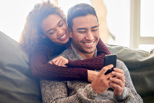 Fotografía de una pareja joven mirando algo en un teléfono celular juntos. - Foto, imagen