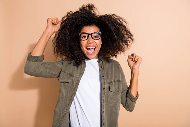 Photo of young crazy african girl celebrate victory fists hands yell awesome isolated over beige color background. - Фото, зображення