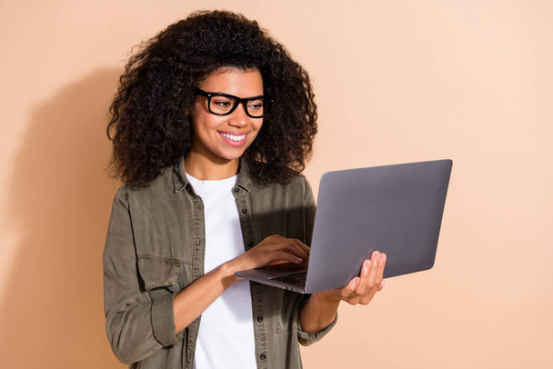 Photo of young pretty african lady type letter report laptop representative expert isolated over beige color background. - Foto, afbeelding