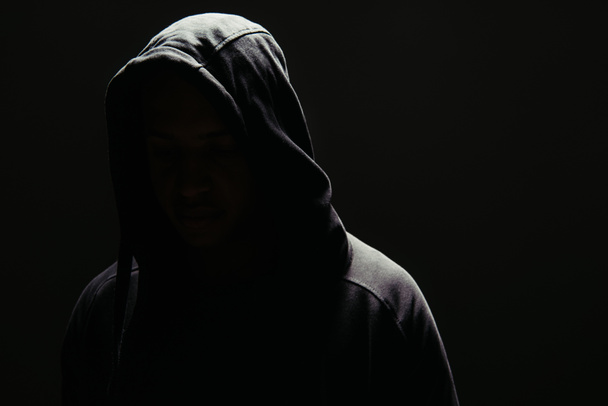 Silhouette of hooligan in hoodie isolated on black  - Foto, imagen
