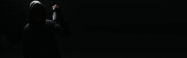 Σιλουέτα χούλιγκαν με μαχαίρι που απομονώνεται σε μαύρο με αντίγραφο χώρου, λάβαρο  - Φωτογραφία, εικόνα