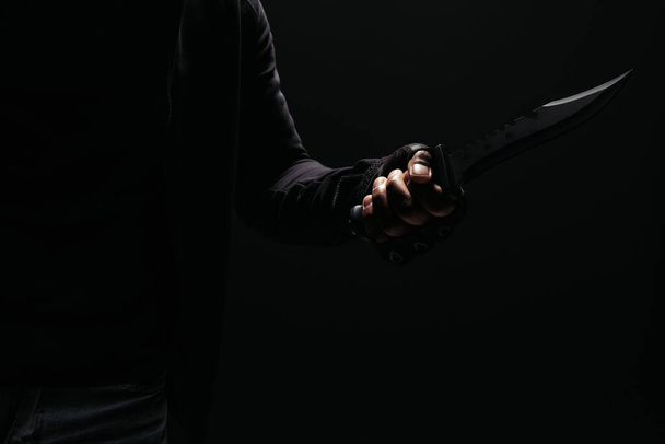 Καλλιεργημένη άποψη του Αφροαμερικανού ληστή κρατώντας μαχαίρι απομονωμένο σε μαύρο  - Φωτογραφία, εικόνα