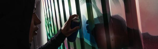 Widok z boku afrykańskiego wandala rysującego graffiti na ścianie, sztandar  - Zdjęcie, obraz