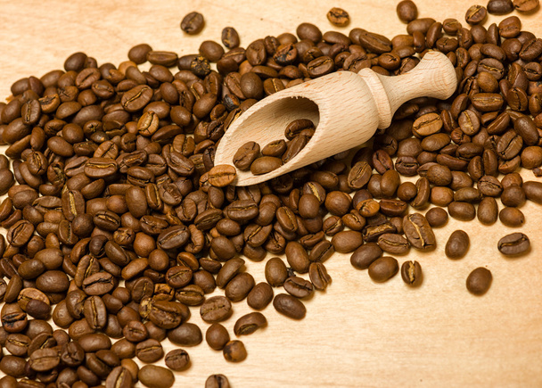 coffee seeds with wooden shovel on wood background - Photo, Image