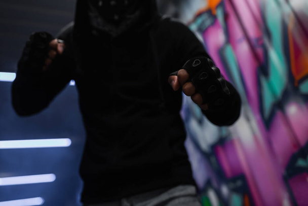Обрізаний вид афроамериканського хулігана в рукавичках, що стоять у бойовій позі в гаражі
  - Фото, зображення