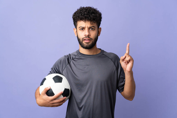 Bonito marroquino jovem jogador de futebol homem sobre isolado no fundo roxo pensando uma ideia apontando o dedo para cima - Foto, Imagem