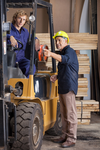 Carpenter Showing Something To Colleague In Forklift - Foto, immagini