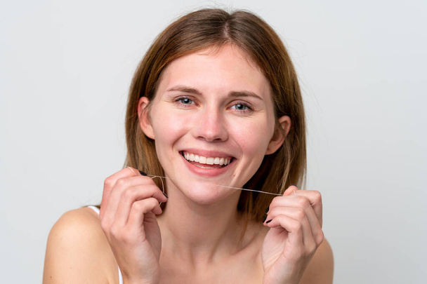 Młoda Angielka używająca nici dentystycznej ze szczęśliwym wyrazem twarzy. Portret z bliska - Zdjęcie, obraz